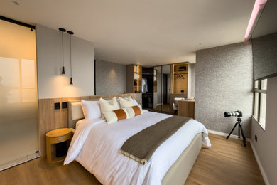Bedroom - mid-sized contemporary master laminate floor, brown floor and wallpaper bedroom idea in Other