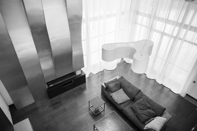 Стильный дизайн: большая гостиная комната в современном стиле с белыми стенами, горизонтальным камином, фасадом камина из металла и черным полом - последний тренд