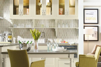Mid-sized elegant single-wall concrete floor and gray floor enclosed kitchen photo in Other with an undermount sink, glass-front cabinets, white cabinets, quartz countertops, gray backsplash, glass tile backsplash, stainless steel appliances and an island