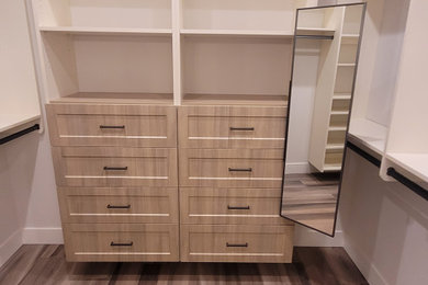 Built-in closet - mid-sized contemporary built-in closet idea in Seattle with recessed-panel cabinets and light wood cabinets