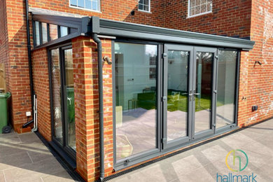 Photo of a medium sized contemporary conservatory in Sussex with a glass ceiling.