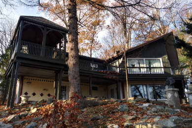 Large elegant green three-story wood house exterior photo in Other with a hip roof and a shingle roof