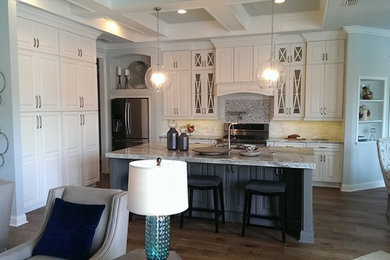 Inspiration for a mid-sized transitional l-shaped brown floor and dark wood floor open concept kitchen remodel in San Diego with an undermount sink, raised-panel cabinets, white cabinets, granite countertops, stainless steel appliances, an island, white backsplash, stone tile backsplash and gray countertops