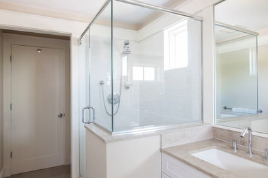 Inspiration for a mid-sized transitional 3/4 bathroom in Boston with shaker cabinets, white cabinets, a corner shower, white tile, subway tile, white walls, an undermount sink, granite benchtops and a hinged shower door.