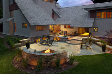 Large arts and crafts backyard concrete patio photo in Milwaukee with a fire pit