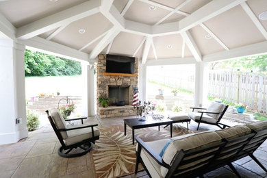 Large arts and crafts backyard tile patio photo in Cincinnati with a fireplace and a roof extension