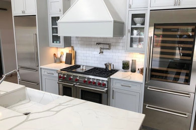 Inspiration for a mid-sized country u-shaped eat-in kitchen in Atlanta with an integrated sink, recessed-panel cabinets, grey cabinets, quartzite benchtops, white splashback, subway tile splashback, stainless steel appliances, with island and white benchtop.