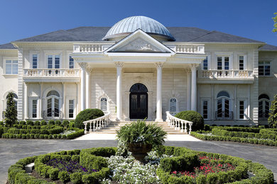 Huge elegant beige two-story stone exterior home photo in DC Metro with a hip roof