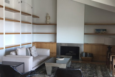 Mittelgroßes, Fernseherloses, Offenes Modernes Wohnzimmer mit weißer Wandfarbe, braunem Holzboden, Kamin und Kaminumrandung aus Metall