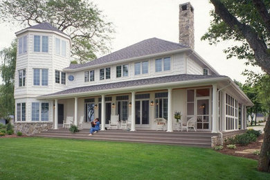 Inspiration for a large timeless white three-story wood house exterior remodel in Cleveland with a shingle roof and a hip roof