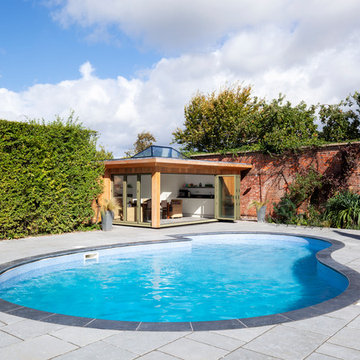 Contemporary pool house amongst a traditional setting.