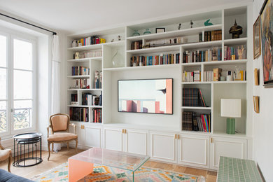 Réalisation d'une grande salle de séjour tradition ouverte avec une bibliothèque ou un coin lecture, un mur blanc, parquet clair, un téléviseur fixé au mur et un sol beige.