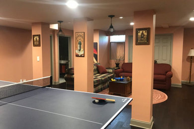 Large eclectic brown floor and laminate floor basement game room photo in Boston
