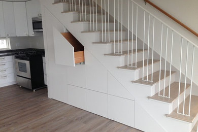 This is an example of a modern wood straight staircase in Portland Maine with painted wood risers.