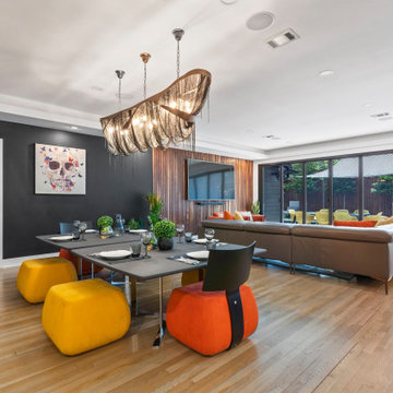 Dramatic dining room with saffron accent chairs and sculptural black chandelier