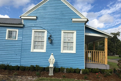 This is an example of a medium sized and blue traditional bungalow detached house in New Orleans with wood cladding, a pitched roof and a metal roof.