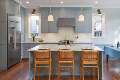 Eat-in kitchen - transitional l-shaped dark wood floor and brown floor eat-in kitchen idea in DC Metro with a farmhouse sink, shaker cabinets, blue cabinets, white backsplash, mosaic tile backsplash, stainless steel appliances, an island and white countertops