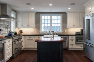 Inspiration for a large timeless dark wood floor and brown floor kitchen remodel in DC Metro with a farmhouse sink, recessed-panel cabinets, white cabinets, wood countertops, gray backsplash, subway tile backsplash, stainless steel appliances and an island
