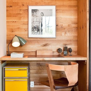 This is an example of a small modern study in Lyon with medium hardwood flooring and a built-in desk.
