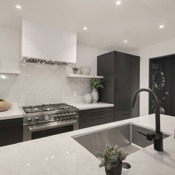 After - Black Cabinetry and Marble Behind a Plaster Hood