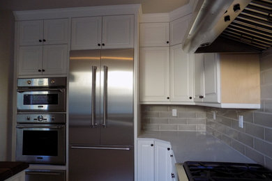 Example of a mid-sized classic u-shaped ceramic tile kitchen pantry design in Los Angeles with a farmhouse sink, shaker cabinets, white cabinets, wood countertops, gray backsplash, stainless steel appliances and an island
