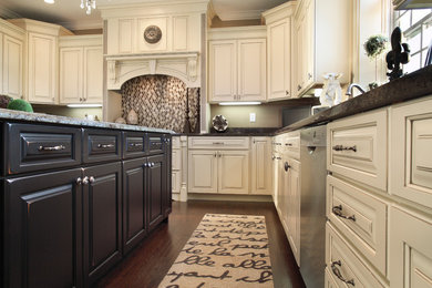 This is an example of a mid-sized traditional u-shaped eat-in kitchen in Boston with raised-panel cabinets, dark hardwood floors, with island, an undermount sink, white cabinets, granite benchtops, beige splashback, porcelain splashback and stainless steel appliances.