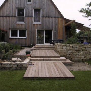 Holzterrasse mit Trockenmauern und Stufen