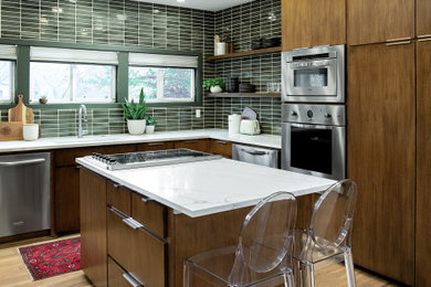 Eat-in kitchen - mid-sized mid-century modern u-shaped light wood floor and beige floor eat-in kitchen idea in Dallas with an undermount sink, flat-panel cabinets, medium tone wood cabinets, quartz countertops, green backsplash, ceramic backsplash, stainless steel appliances, an island and white countertops