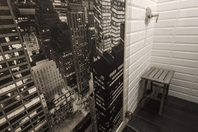 Walk-in shower - transitional white tile and subway tile black floor and wallpaper walk-in shower idea in Denver with a wall-mount toilet, a pedestal sink, a hinged shower door, a niche and a freestanding vanity