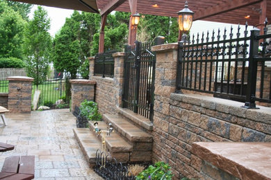 Photo of a mid-sized traditional partial sun front yard concrete paver landscaping in New York for spring.