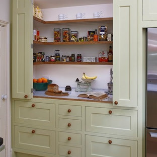 На фото: маленькая кухня в стиле кантри с обеденным столом, врезной раковиной, фасадами в стиле шейкер, зелеными фасадами, столешницей из гранита, полом из известняка и островом с