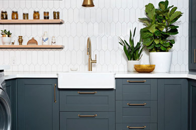 Inspiration for a country laundry room in Toronto with a farmhouse sink, shaker cabinets, blue cabinets, quartz benchtops, linoleum floors, a side-by-side washer and dryer, grey floor and white benchtop.