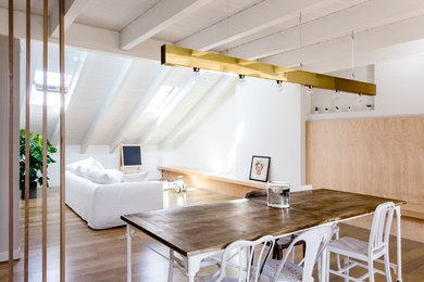 Contemporary loft-style living room in Milan with white walls and dark hardwood floors.