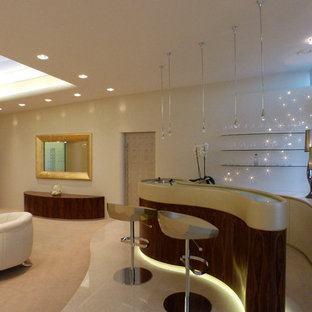 Ejemplo de salón para visitas mediterráneo con paredes beige, suelo de contrachapado y televisor retractable