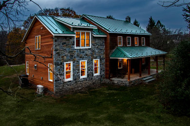 Ejemplo de fachada de casa marrón campestre de tamaño medio de dos plantas con revestimiento de madera, tejado a dos aguas, techo verde y tablilla