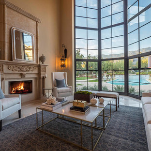 Mediterranean living room in Los Angeles with brown walls, a standard fireplace, no tv and beige floors.