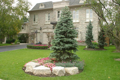 Inspiration for a large front yard driveway in Toronto.