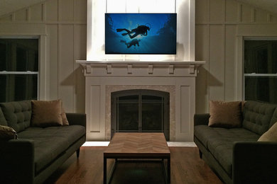 Example of a mid-sized beach style enclosed dark wood floor home theater design in Chicago with white walls and a wall-mounted tv