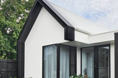 Design ideas for a large tropical one-storey white house exterior in Geelong with concrete fiberboard siding, a gable roof, a metal roof and a white roof.