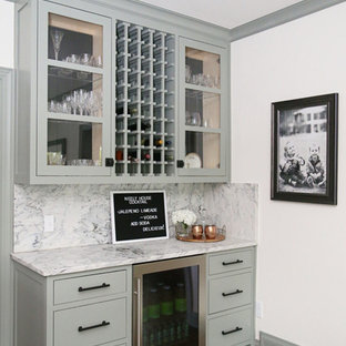 他の地域の小さいトランジショナルスタイルのおしゃれなウェットバー (ガラス扉のキャビネット、緑のキャビネット、大理石カウンター、グレーのキッチンパネル、大理石の床、無垢フローリング、茶色い床、グレーのキッチンカウンター) の写真