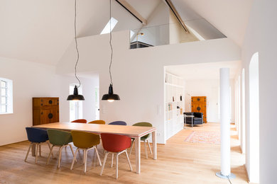 Skandinavisches Esszimmer mit weißer Wandfarbe und hellem Holzboden in Hamburg