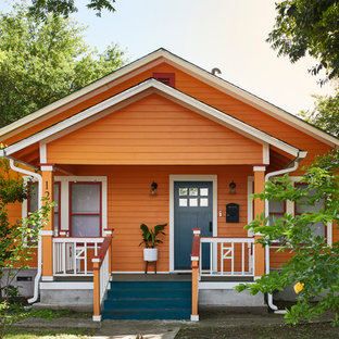 Неиссякаемый источник вдохновения для домашнего уюта: одноэтажный фасад частного дома среднего размера оранжевого цвета в стиле фьюжн с облицовкой из дерева и двускатной крышей