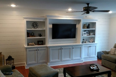 Photo of a mid-sized country family room in Detroit with white walls, medium hardwood floors and a built-in media wall.