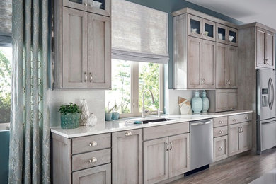 Inspiration for a large transitional u-shaped medium tone wood floor eat-in kitchen remodel with an undermount sink, shaker cabinets, white cabinets, quartz countertops, white backsplash, subway tile backsplash, stainless steel appliances and an island