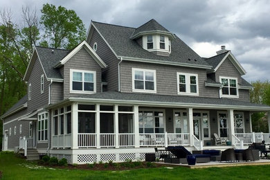 Inspiration for a large timeless gray three-story wood house exterior remodel in Milwaukee with a shingle roof and a clipped gable roof