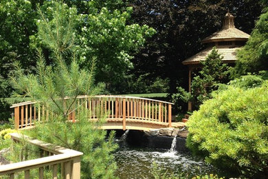 Photo of a mid-sized asian full sun backyard landscaping in New York with decking for fall.