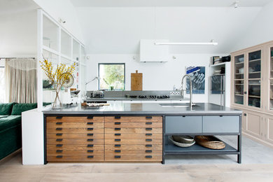 Inspiration for a mid-sized contemporary u-shaped open plan kitchen in Other with a double-bowl sink, flat-panel cabinets, medium wood cabinets, concrete benchtops, grey splashback, stainless steel appliances, light hardwood floors, grey benchtop, a peninsula and brown floor.