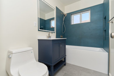 Bathroom - mid-sized craftsman 3/4 ceramic tile, gray floor and single-sink bathroom idea in Orange County with shaker cabinets, blue cabinets, white walls, white countertops and a freestanding vanity