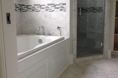 Design ideas for a mid-sized traditional master bathroom in Other with raised-panel cabinets, white cabinets, a drop-in tub, an alcove shower, a two-piece toilet, white tile, porcelain tile, green walls, porcelain floors, a drop-in sink, marble benchtops, white floor and a hinged shower door.
