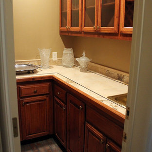 Inredning av ett klassiskt stort kök, med luckor med upphöjd panel, skåp i mellenmörkt trä, laminatbänkskiva, beige stänkskydd, tegelgolv och en nedsänkt diskho